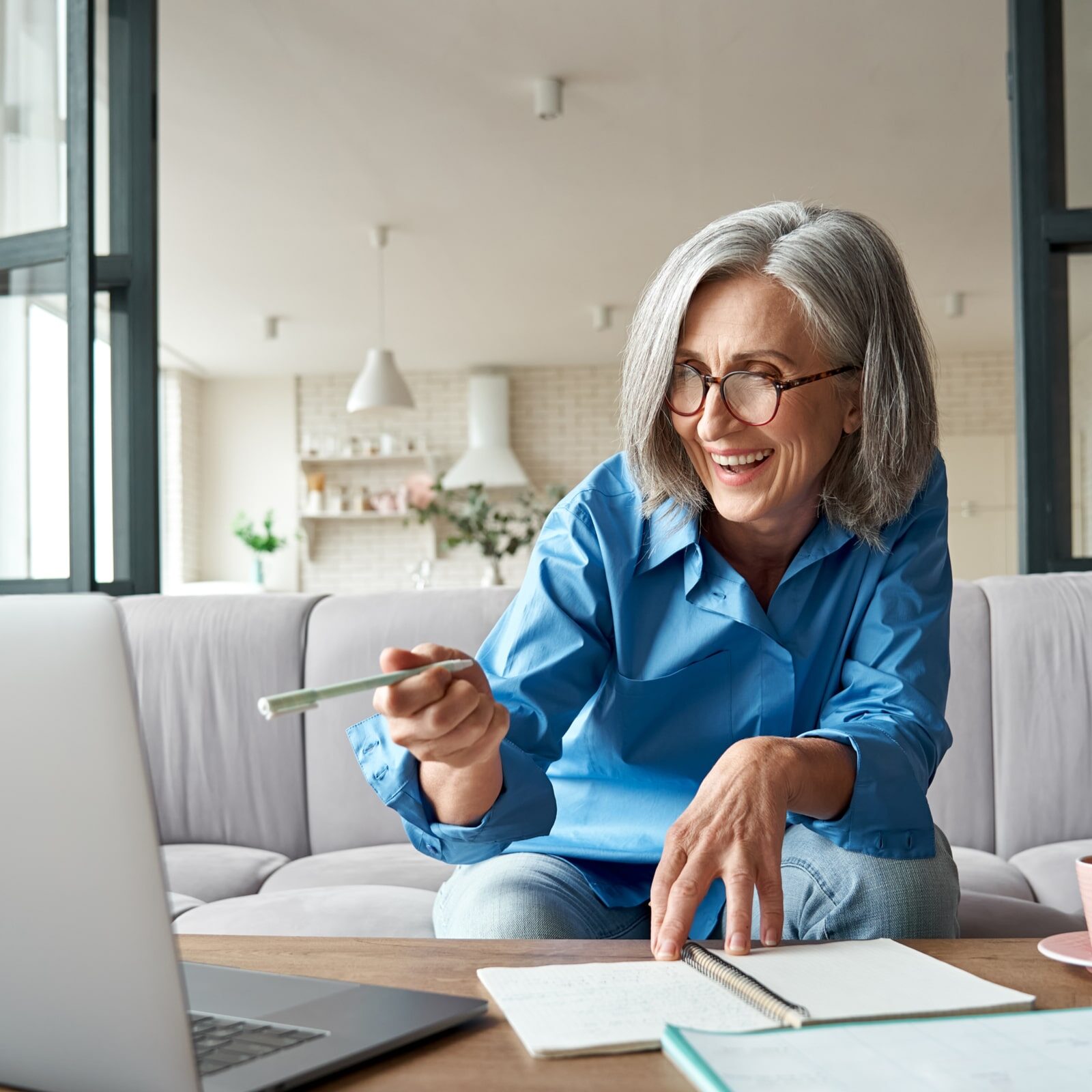 Happy mature woman video calling on laptop