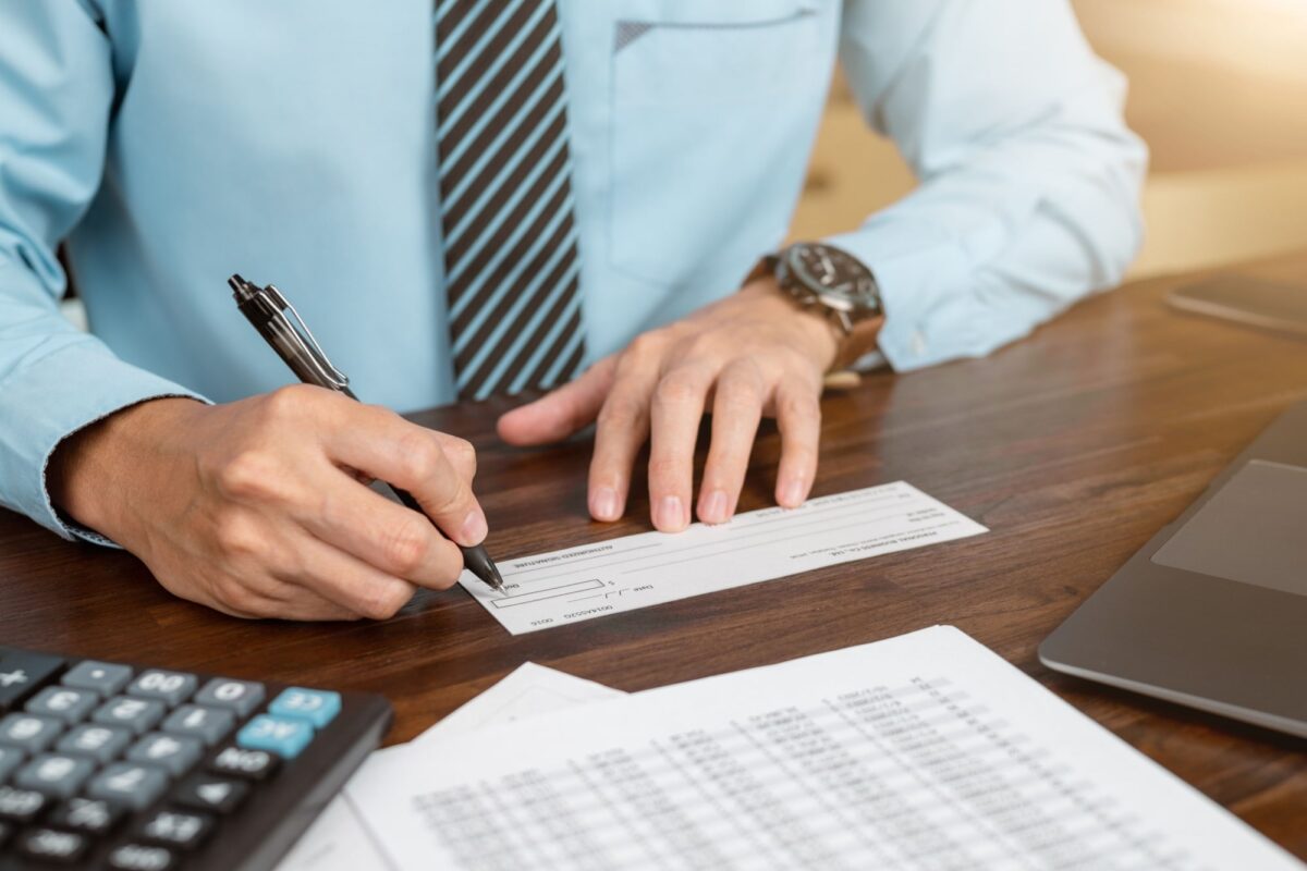 Businessman hands writing and signing check
